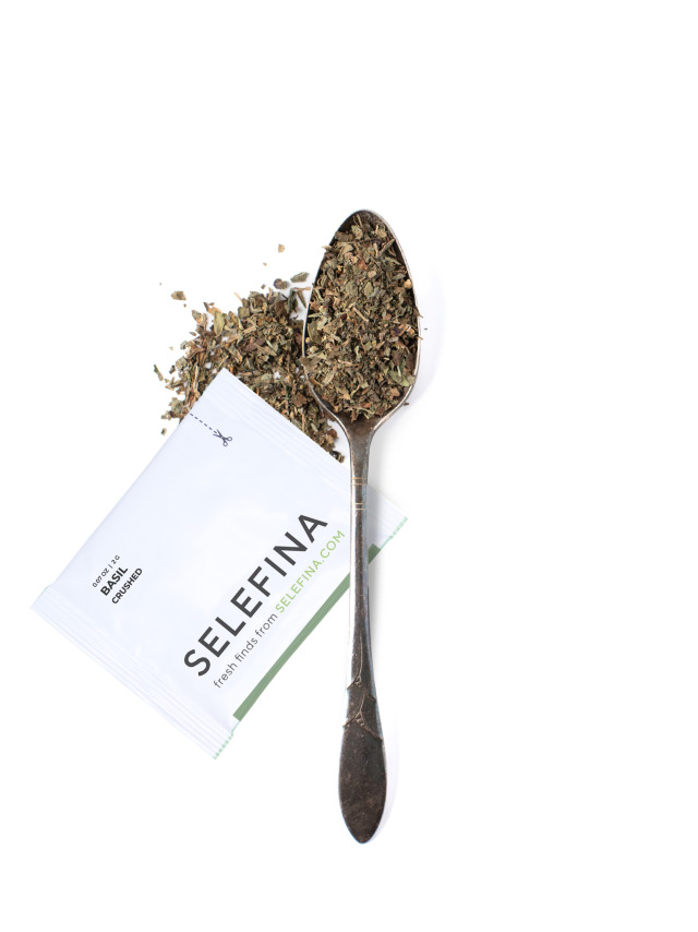 A Selefina Try-Me packet of crushed basil beside a spoonful of it