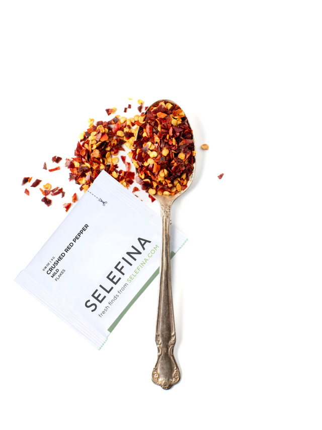 A Selefina Try-Me packet of mild crushed red pepper beside a spoonful of it