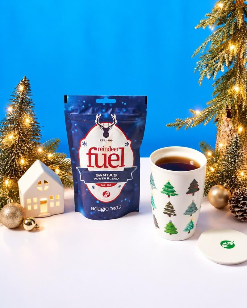 Reindeer Fuel pouch beside a tree-print mug of tea with glowing mini trees and gold ornaments